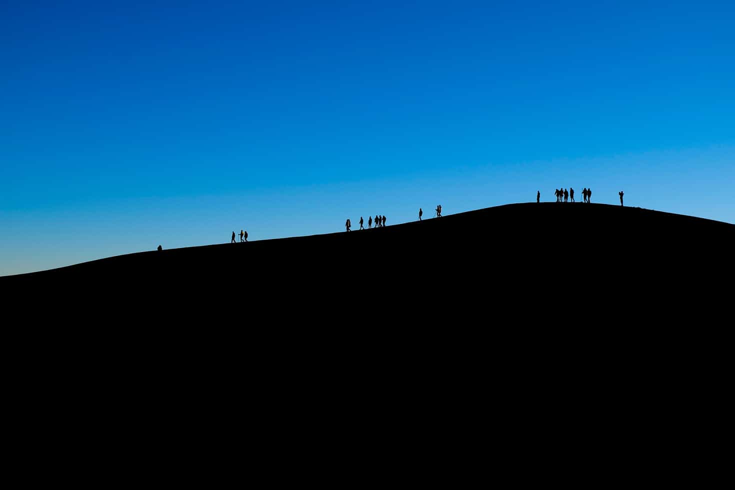 Hikers silhouetted while waiting for sunrise on Acatenango Volcano